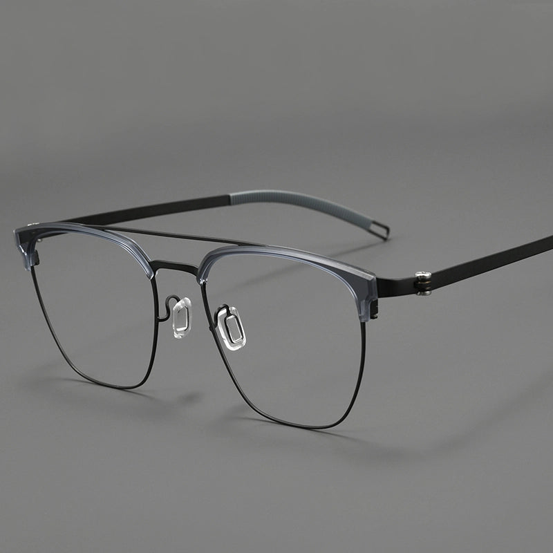A pair of browline designer glasses with a dark gray and black pure titanium eyeglass frame, clear lenses, and black temple arms, shown on a neutral gray background.