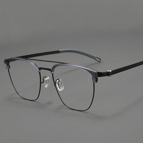 A pair of browline designer glasses with a dark gray and black pure titanium eyeglass frame, clear lenses, and black temple arms, shown on a neutral gray background.