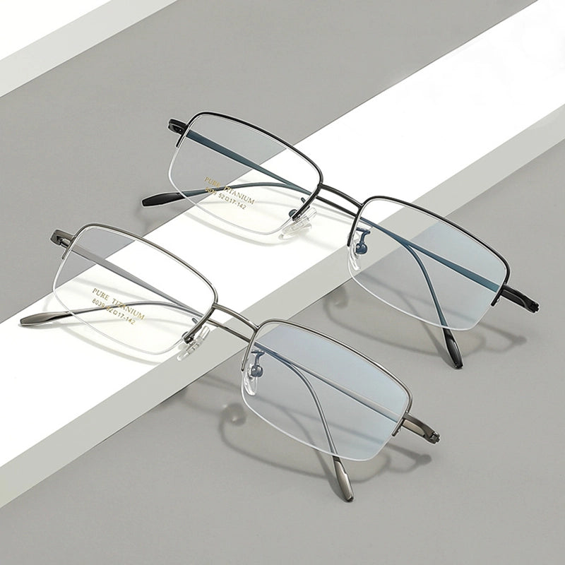 Two pairs of pure titanium half frame glasses for men from Verhalo Vision displayed on a clean, geometric gray and white background. One pair has a thin black metal frame, and the other has a thin silver metal frame, both with clear lenses.