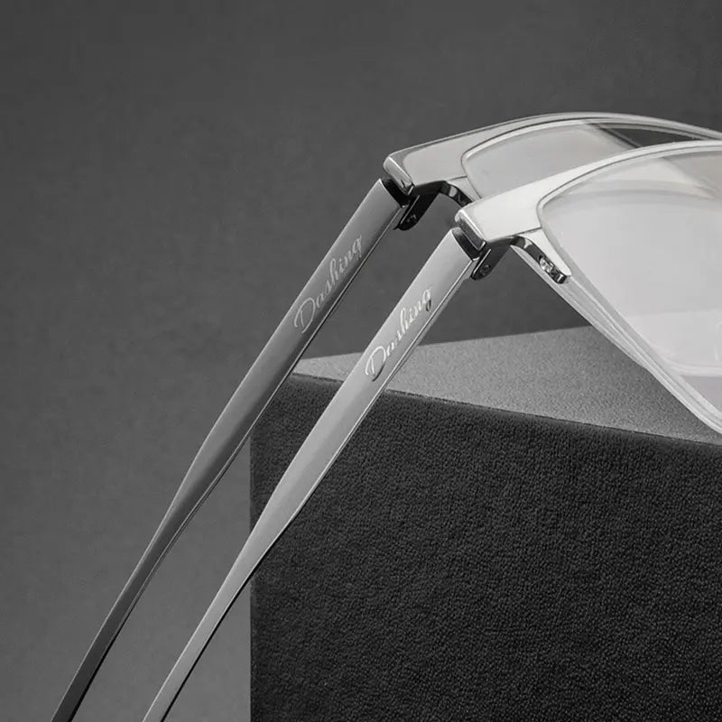 Close-up of a pair of Pure Titanium Large Semi Rimless Spectacles for Men from Verhalo Vision with slim silver metal arms resting on a dark textured display block. 
