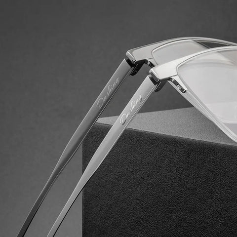 Close-up of a pair of Pure Titanium Large Semi Rimless Spectacles for Men from Verhalo Vision with slim silver metal arms resting on a dark textured display block. 