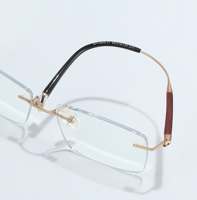 Pair of rectangle rimless titanium  glasses with gold frame and wooden accents on a light gray background | Verhalovision
