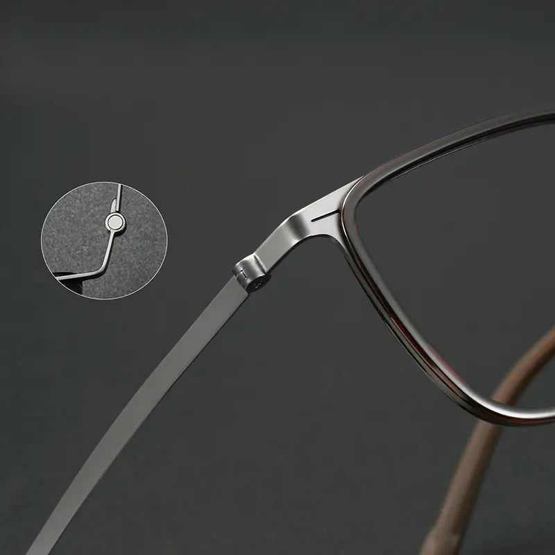 Close-up of a pair of titanium eyeglass arms showing a titanium hinge detail, with a circular inset highlighting the hinge construction, on a dark gray background.