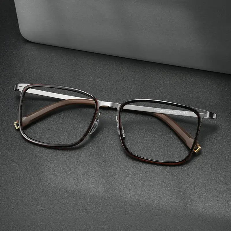 Rectangular Titanium Glasses for Men and Women from Verhalo Vision with a dark red TR90 front, silver-toned titanium temples, and gold-toned hinge accents, displayed on a dark gray surface with a gray case in the background.